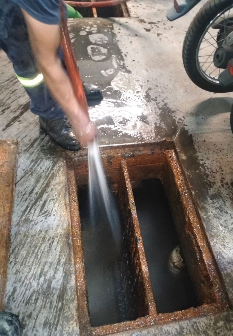 Operador aplicando hidrojet sobre una trampa de grasa